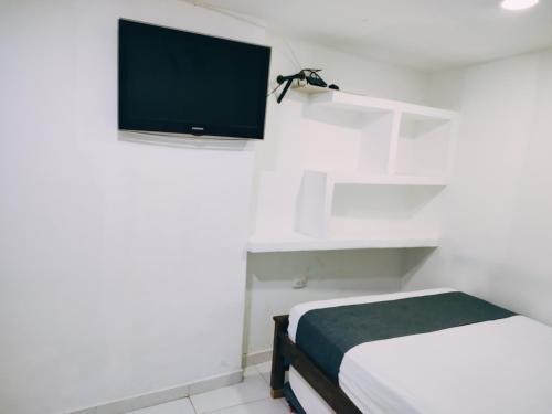 Habitación con cama y TV de pantalla plana. en Hotel Tranvia, en Santa Marta