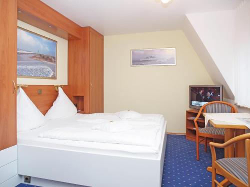 a hotel room with a bed and a table at Haus Thorwarth - Hotel garni in Cuxhaven