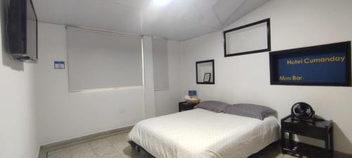 1 dormitorio blanco con 1 cama y TV en HOTEL CUMANDAY, en Pereira