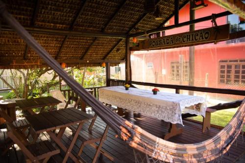 uma mesa e cadeiras num alpendre de um restaurante em Pousada Do Chicão na Ilha do Mel