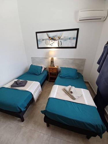 a room with two beds and a lamp in it at Villa vue mer 180°, piscine in Saint-François