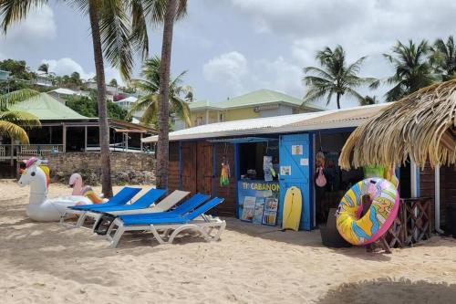 a beach with lounge chairs and a building on the beach at Villa vue mer 180°, piscine in Saint-François