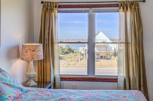 a bedroom with a window with a view of the ocean at Whaley Topsail Beach in Topsail Beach
