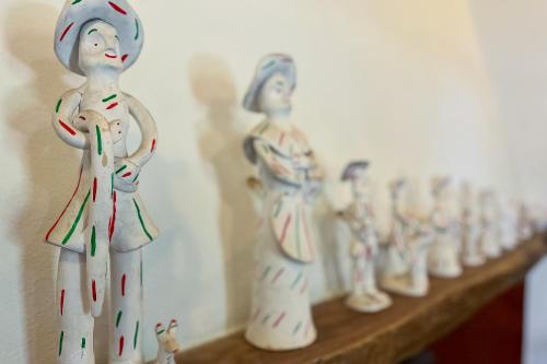 a row of ceramic figurines on a wooden shelf at FINCA SA SINI in Búger