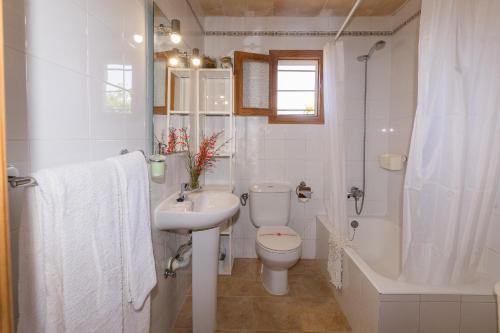 uma casa de banho branca com um WC e um lavatório em FINCA SA SINI em Búger