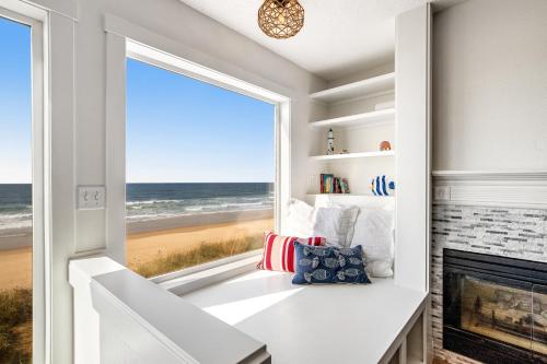 a room with a fireplace and a window with a view of the beach at Sand Castle 1 in Rockaway Beach