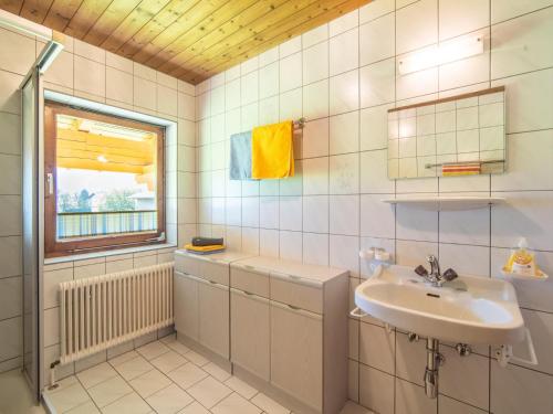 ein weiß gefliestes Bad mit einem Waschbecken und einem Fenster in der Unterkunft Fankhauser I in Zell am Ziller