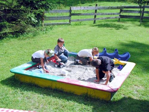 a group of four children playing in a sandbox at Almstüberl - Schiestl's Ferienhütten in Mayrhofen