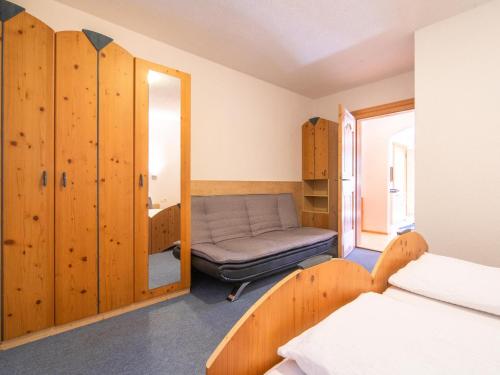 um quarto com uma cama e uma cadeira em Hechenberger em Wenns