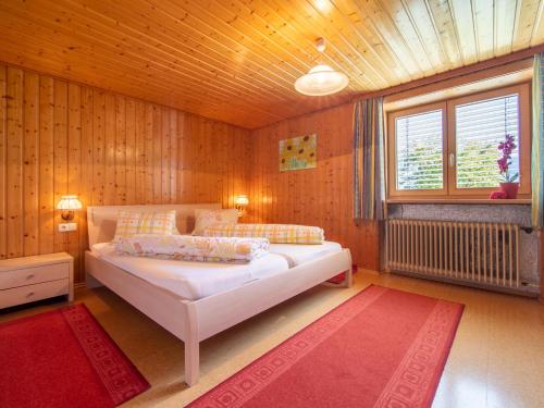 ビュルサーベルクにあるSchallertの木製の壁のベッドルームで、白い大型ベッドが備わります。
