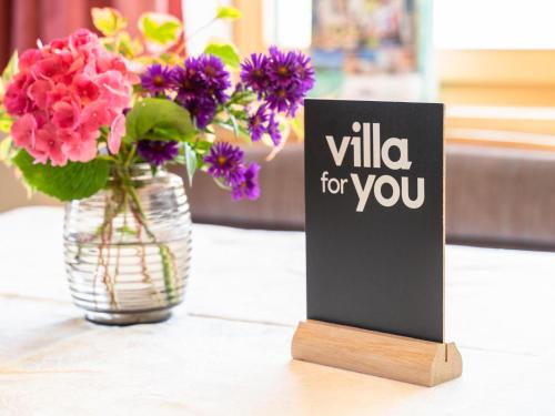 a vase of flowers and a sign on a table at Schallert in Bürserberg