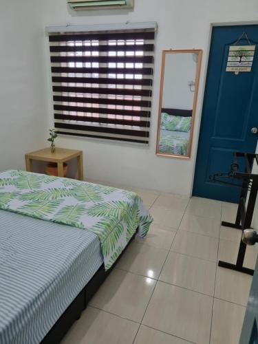 een slaapkamer met een bed, een blauwe deur en een raam bij PRIVATE POOL Ssue Klebang Ipoh Homestay-Guesthouse With Wifi & Netflix in Chemor
