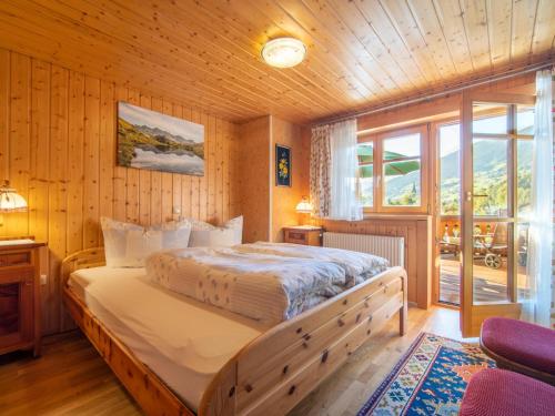 a bedroom with a large bed in a wooden room at Landhaus Barbara in Silbertal