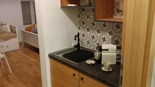 a kitchen with a sink with a mixer in it at Apartamenty Solo na Molo in Sopot