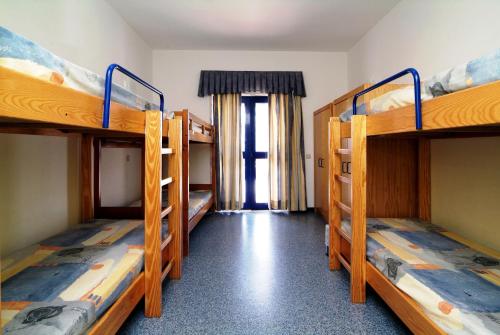 a room with three bunk beds in a room at HI Beja - Pousada de Juventude in Beja