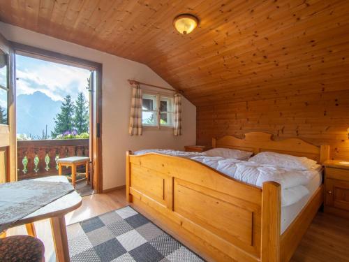 una camera da letto con un grande letto in una camera in legno di Sonnrasthütte a Untergaimberg