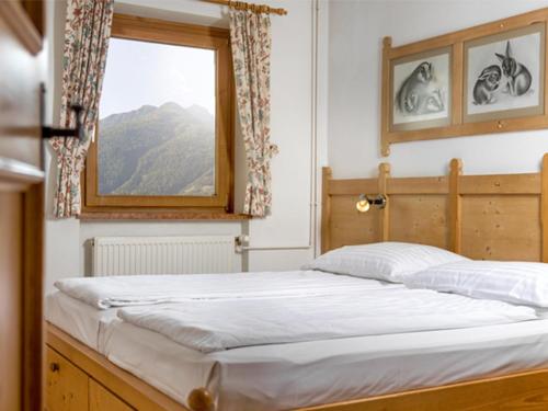 Bett in einem Zimmer mit Fenster in der Unterkunft Matrei Park 55 in Matrei in Osttirol