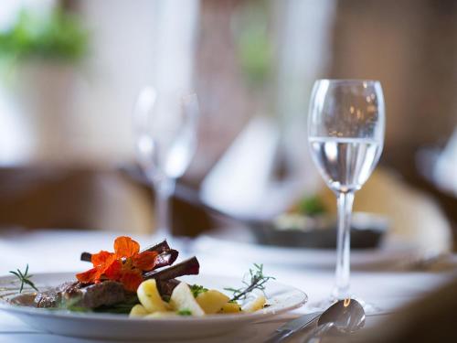 a plate of food and a glass of wine on a table at Matrei Park 90 in Klaunz