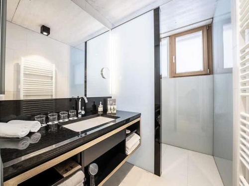 uma casa de banho com um lavatório e um espelho grande em Chalet Klassik em Kals am Grossglockner