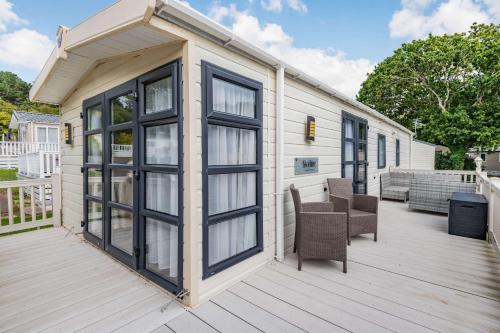 a mobile home with windows and a deck at Skyline Lodge in Lymington