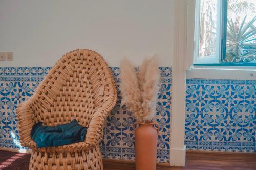 a wicker chair and a vase in a room at Chalet Santa Iria in Santarém