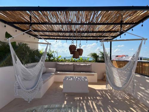 two hammocks on a patio with a view of the ocean at Dream penthouse with private rooftop and amazing views in Cancún