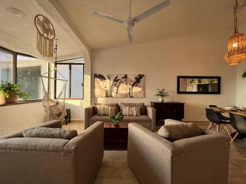 a living room with two couches and a ceiling fan at Dream penthouse with private rooftop and amazing views in Cancún