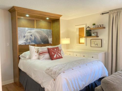 a bedroom with a bed with a picture of a dog at Modern Mountainside Ski In/Ski Out Studio at Blue in Blue Mountains