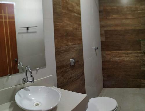 a bathroom with a sink and a toilet and a mirror at Pousada Porto Tutóia in Tutóia