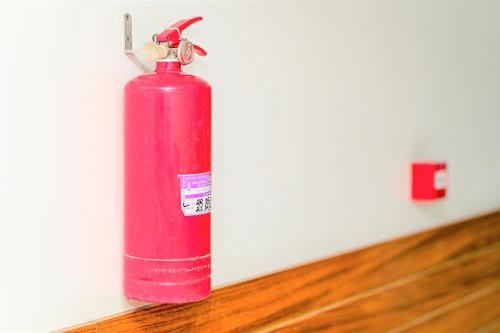a pink fire extinguisher sitting on the floor at The Shahin Residence - Mohakhali in Dhaka