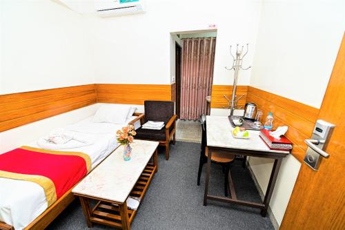 a room with a bed and a desk and a table at The Shahin Residence - Mohakhali in Dhaka