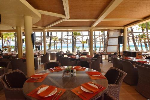 a dining room with a table and chairs and windows at Ambassador In Paradise in Boracay