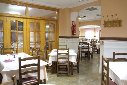 a dining room with tables and chairs in a restaurant at Hostal Restaurante La Masía in Villareal