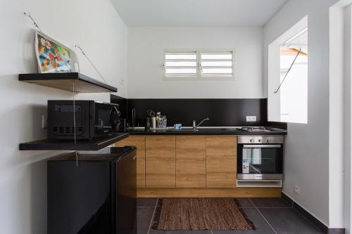 a kitchen with a microwave oven and a sink at Domaine de Sainval in Sainte-Rose