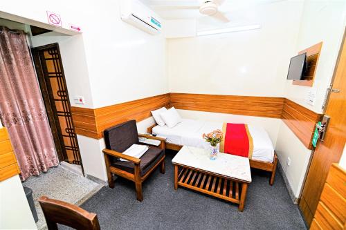 a room with a bed and a table and a chair at The Shahin Residence - Mohakhali in Dhaka