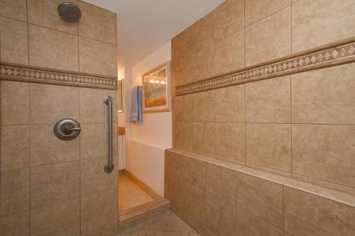 a shower with a glass door in a bathroom at Diamond Head Beach Hotel in Honolulu