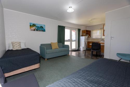 a living room with a bed and a couch at Cosy Corner Holiday Park in Mount Maunganui