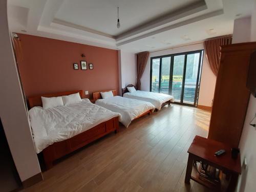 a bedroom with two beds and a large window at Homestay 715 in Sa Pa