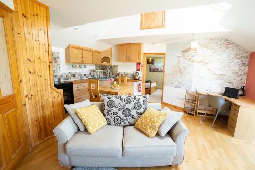 a living room with a couch and a kitchen at The Story House Cottage - Mendips Countryside near Axbridge in Axbridge