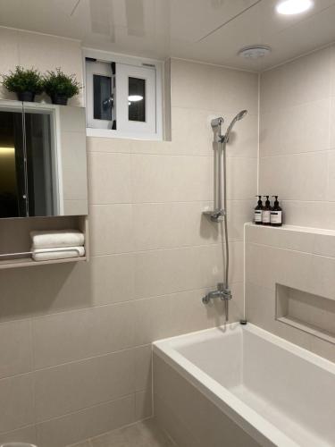 a bathroom with a bath tub and a shower at Dontan terrace in Hwaseong