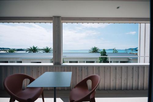 a table and two chairs in front of a large window at Colorit GOTO ISLANDS in Goto