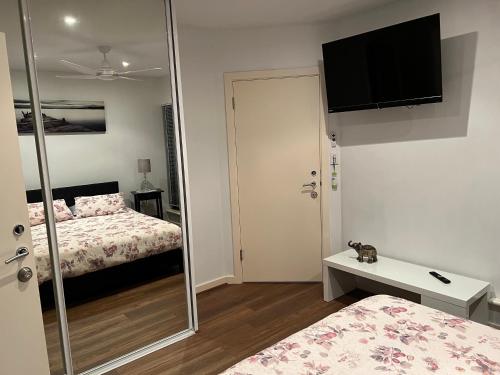 ビクターハーバーにあるVictor Holidaysのベッド2台と鏡のある寝室