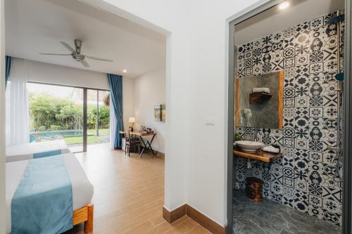 een slaapkamer met een bed en een muur met een spiegel bij Ngoc An Bang Villa in An Bàn (2)