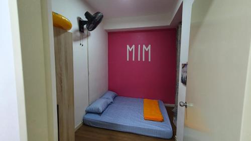 a small bed in a room with a pink wall at New Modern Condo with Pool at Bangi in Kampong Tangkas