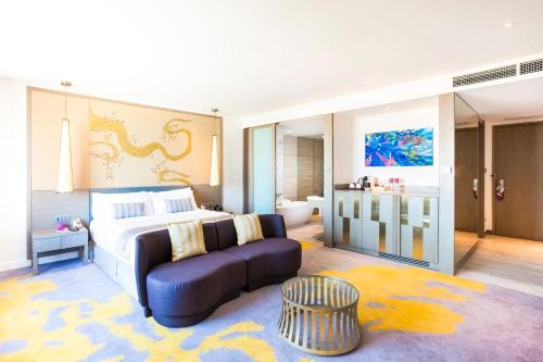 a bedroom with a bed and a couch in a room at Crowne Plaza Vientiane by IHG in Vientiane