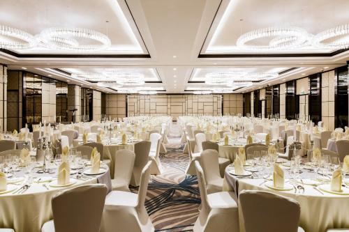 a large banquet hall with white tables and chairs at Crowne Plaza Vientiane by IHG in Vientiane