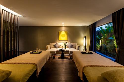 a hotel room with two beds and a couch at Crowne Plaza Vientiane by IHG in Vientiane