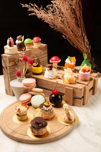 a table topped with different types of pastries on plates at Crowne Plaza Vientiane by IHG in Vientiane