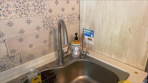 a sink with a faucet in a kitchen at 小古堡民宿 The Little Castle - 完成訂房後務必要與屋主聯絡確認 in Tainan