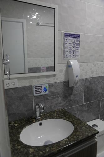 y baño con lavabo, espejo y aseo. en Posada Mango House en San Andrés